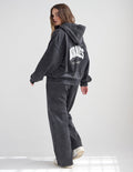 Unisex full-zip cotton hoodie in washed-black and white, styled for a relaxed streetwear look.