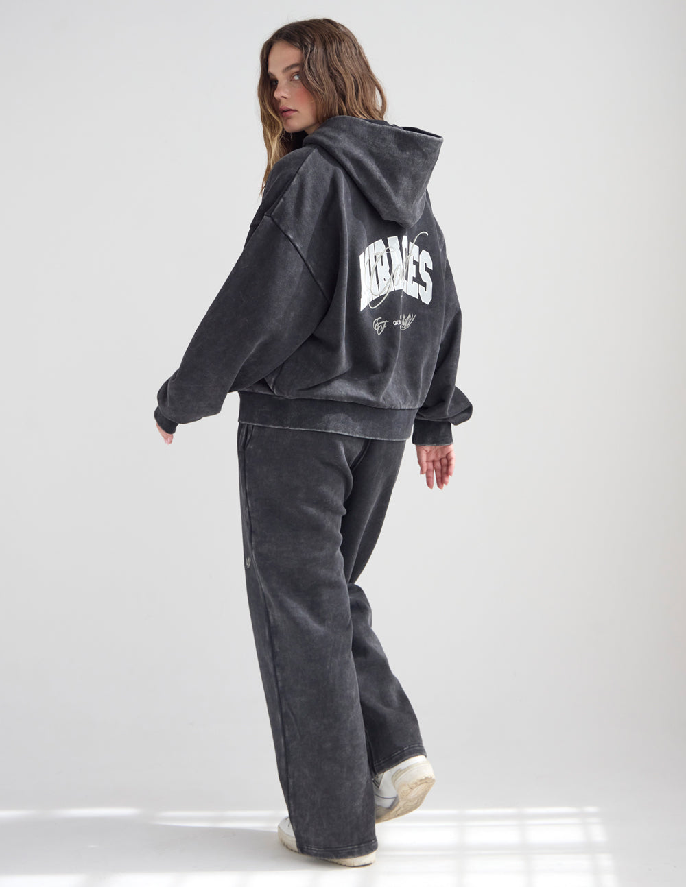 Unisex full-zip cotton hoodie in washed-black and white, styled for a relaxed streetwear look.