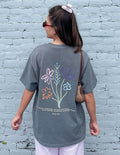 Charcoal grey unisex t-shirt with God's Still Working graphic design.
