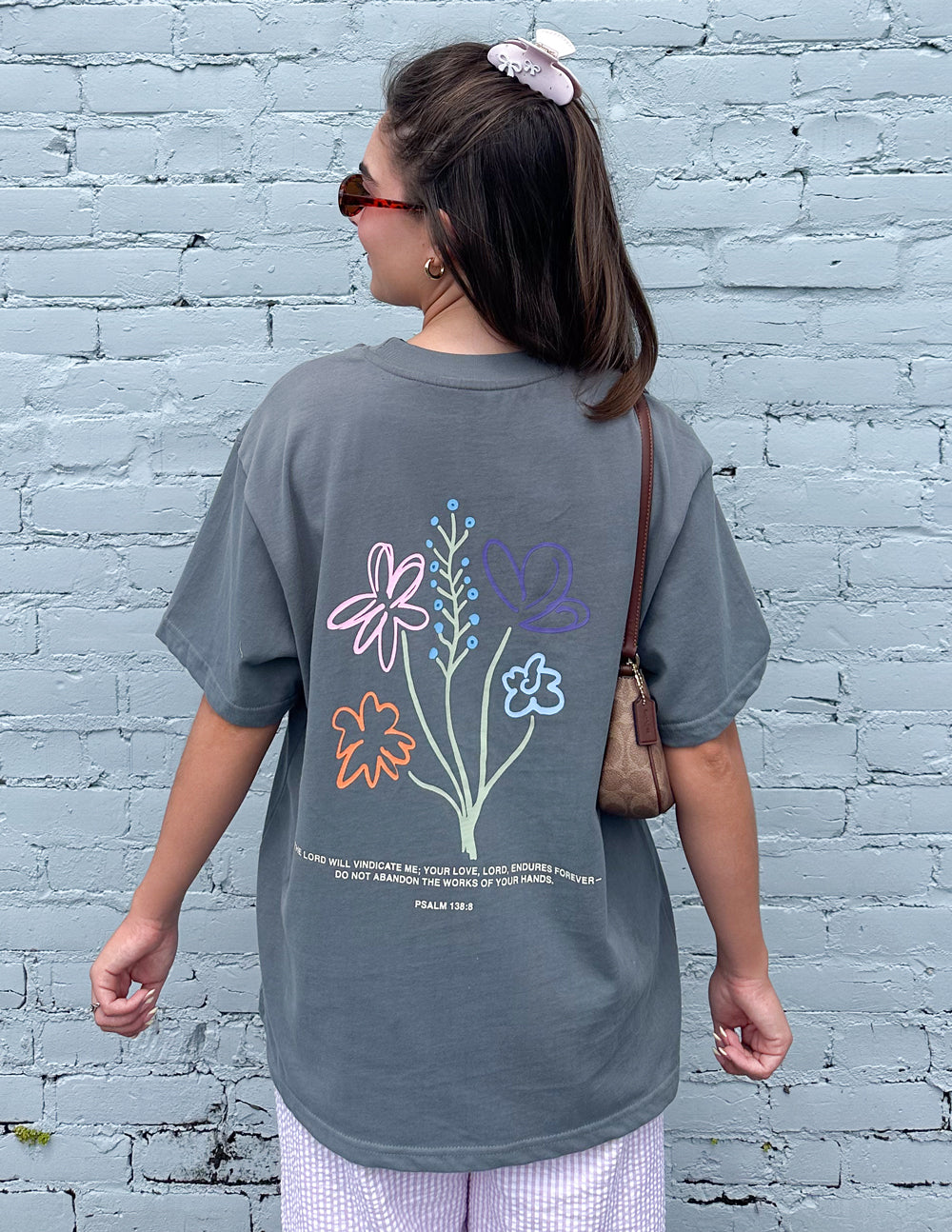 Charcoal grey unisex t-shirt with God's Still Working graphic design.