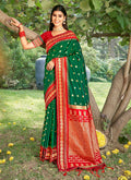 Vibrant green soft silk saree featuring a smooth, luxurious texture and matching blouse piece.