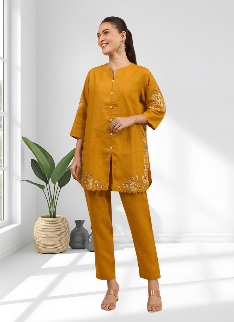 A woman wearing a vibrant yellow cotton linen cord set with delicate embroidery and matching trousers.