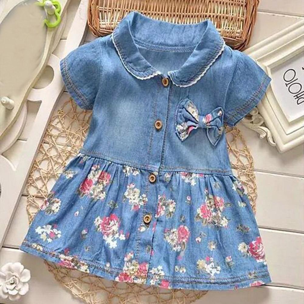 Little girl wearing a navy blue floral print dress with a bowknot and turn-down collar
