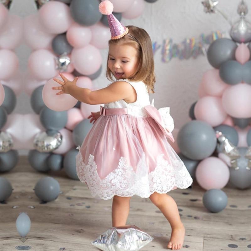 Baby girl wearing an elegant birthday dress with a large decorative bow