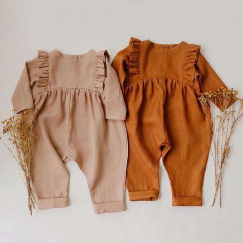 Close up of a modern knitted cotton long sleeve baby romper in an elegant autumn style