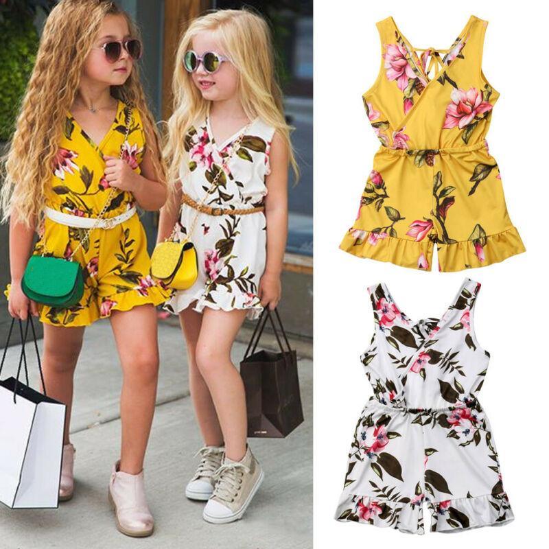 Baby girl wearing a sleeveless yellow and white floral print cotton romper for summer