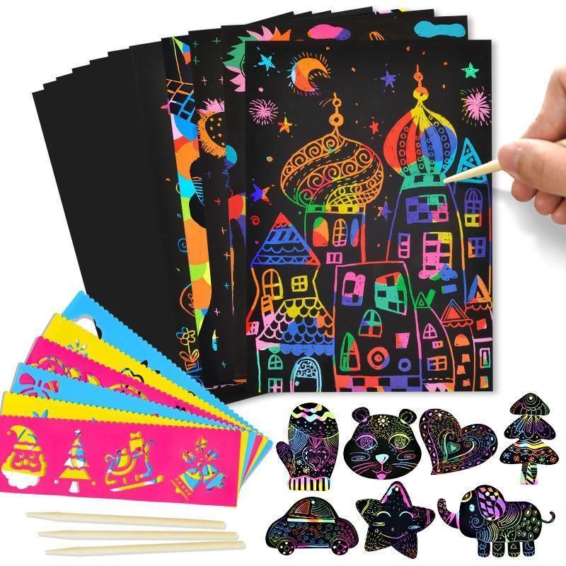 A set of rainbow scratch art paper with black coating, wooden stylus, and drawing stencils on a desk.