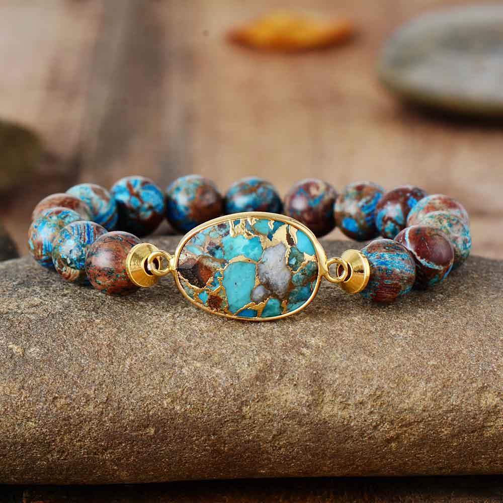 Multicolor chakra bead bracelet featuring natural lava rock and tiger eye stones on a white background.