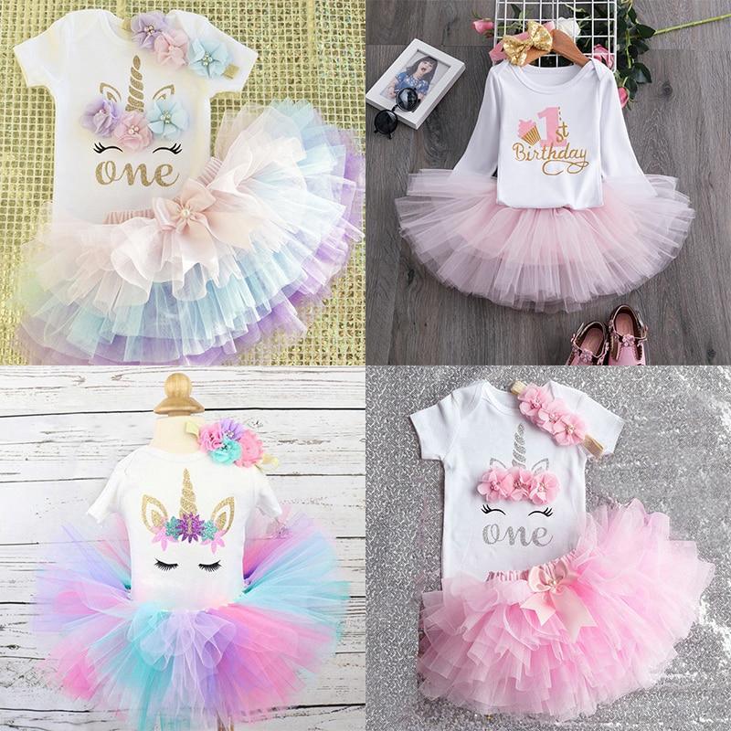 Baby girl wearing a pink and gold 1st birthday unicorn tutu dress with a big bow.