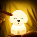 Cute silicone puppy-shaped night light glowing on a nightstand
