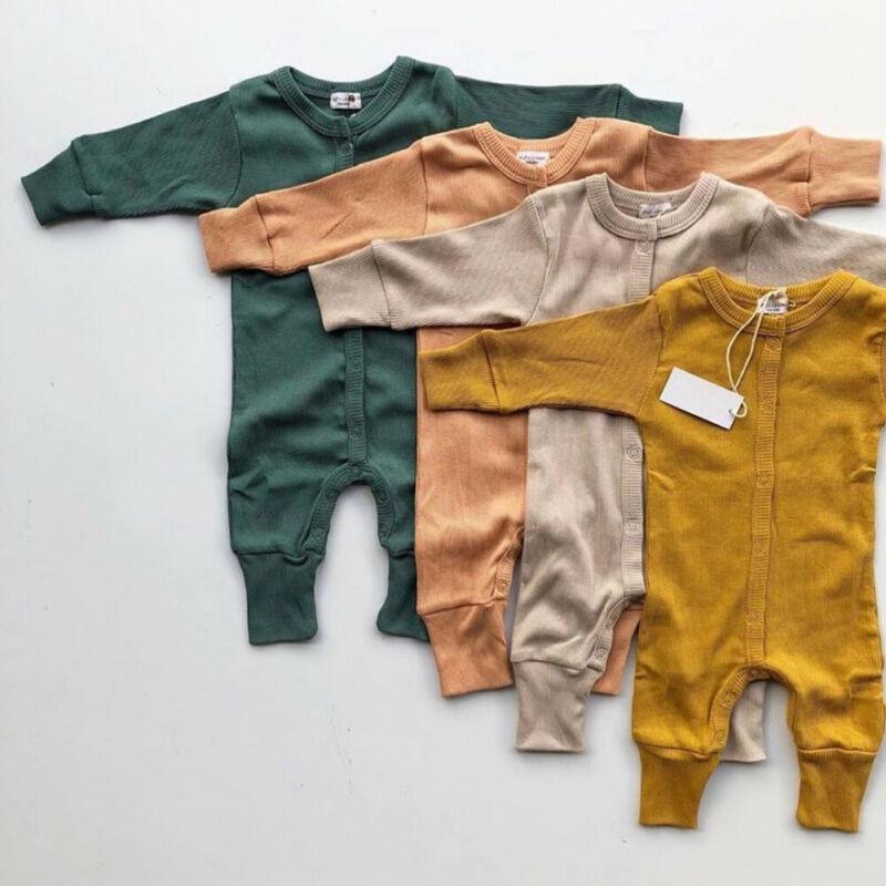 Baby wearing a minimalist long sleeve knitted romper in a muted earth tone, featuring a crew neck and snap closure.