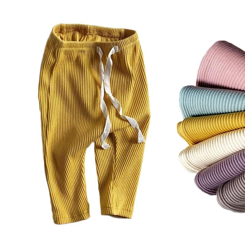 A pair of soft, ribbed solid-color leggings for babies and toddlers with an elastic waistband.