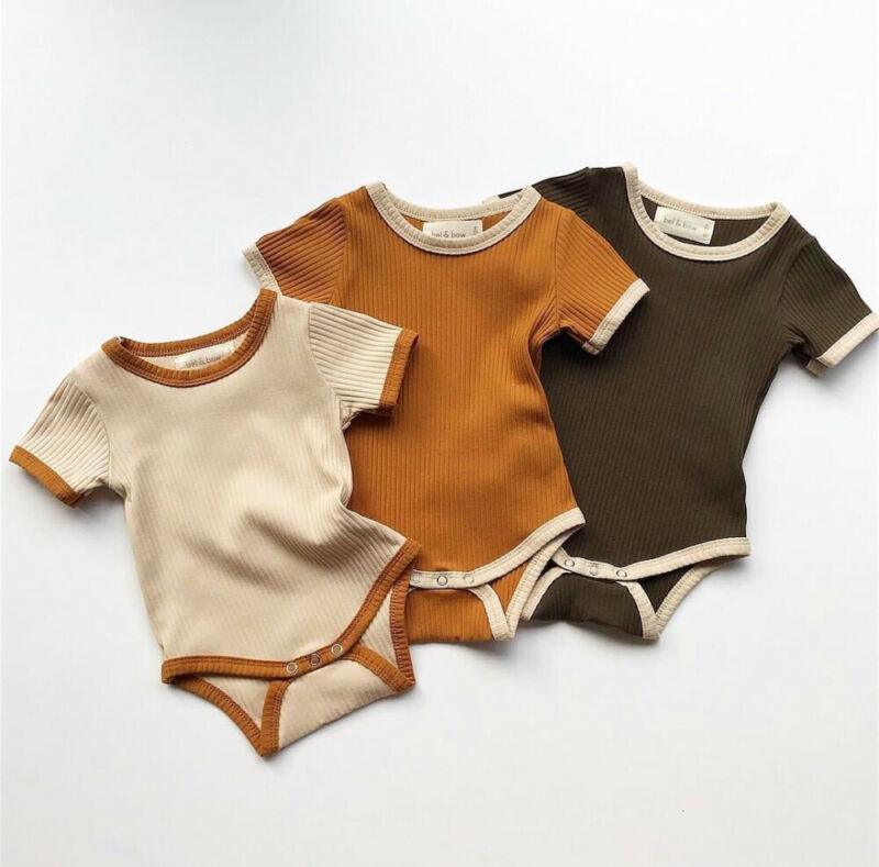 A minimalist newborn knit romper in a solid color with short sleeves and a crew neckline