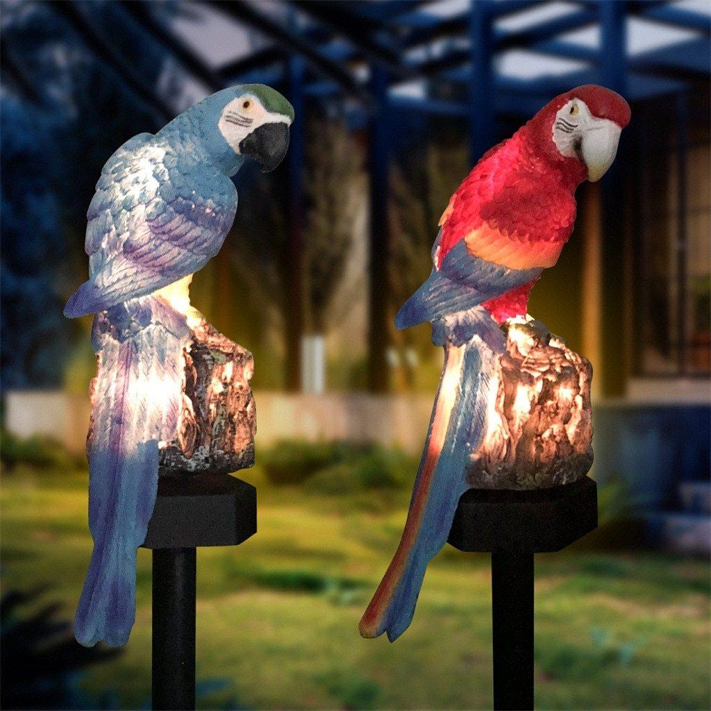 Vibrant parrot-shaped resin solar garden lamp sitting in a lush lawn setting