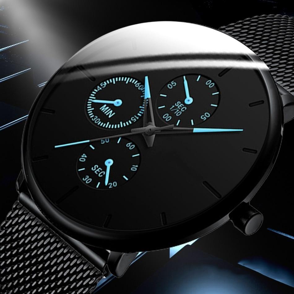 Minimalist black unisex quartz watch with slim mesh band on a clean background