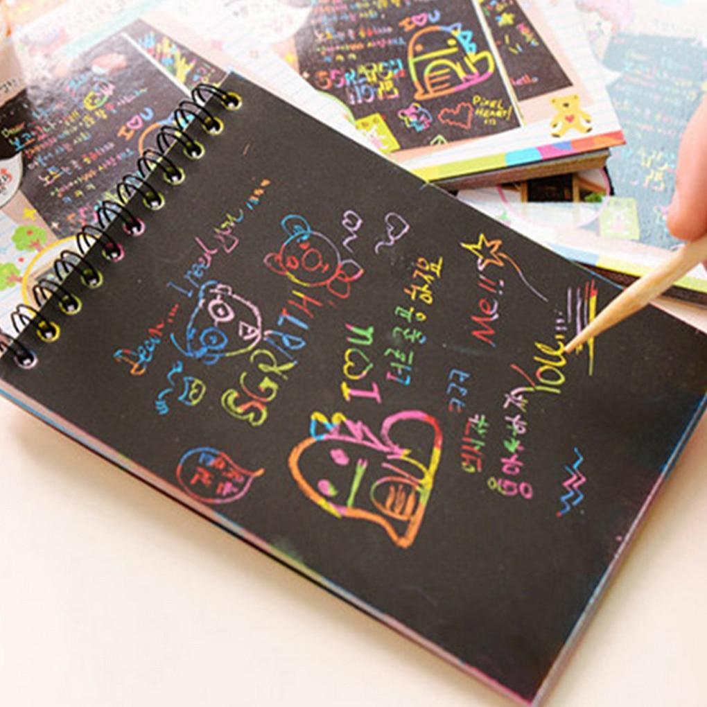 A creative scratch sketchbook with black matte pages and a wooden stylus for rainbow drawing.