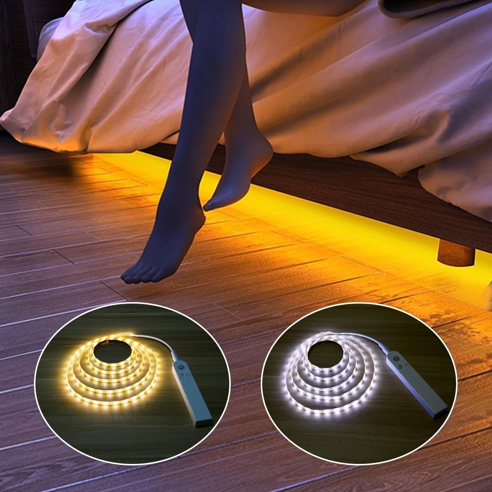 Warm white motion-sensor LED strip light under a bed frame