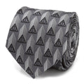 Close up of a gray silk necktie featuring a repeating black Deathly Hallows symbol pattern.