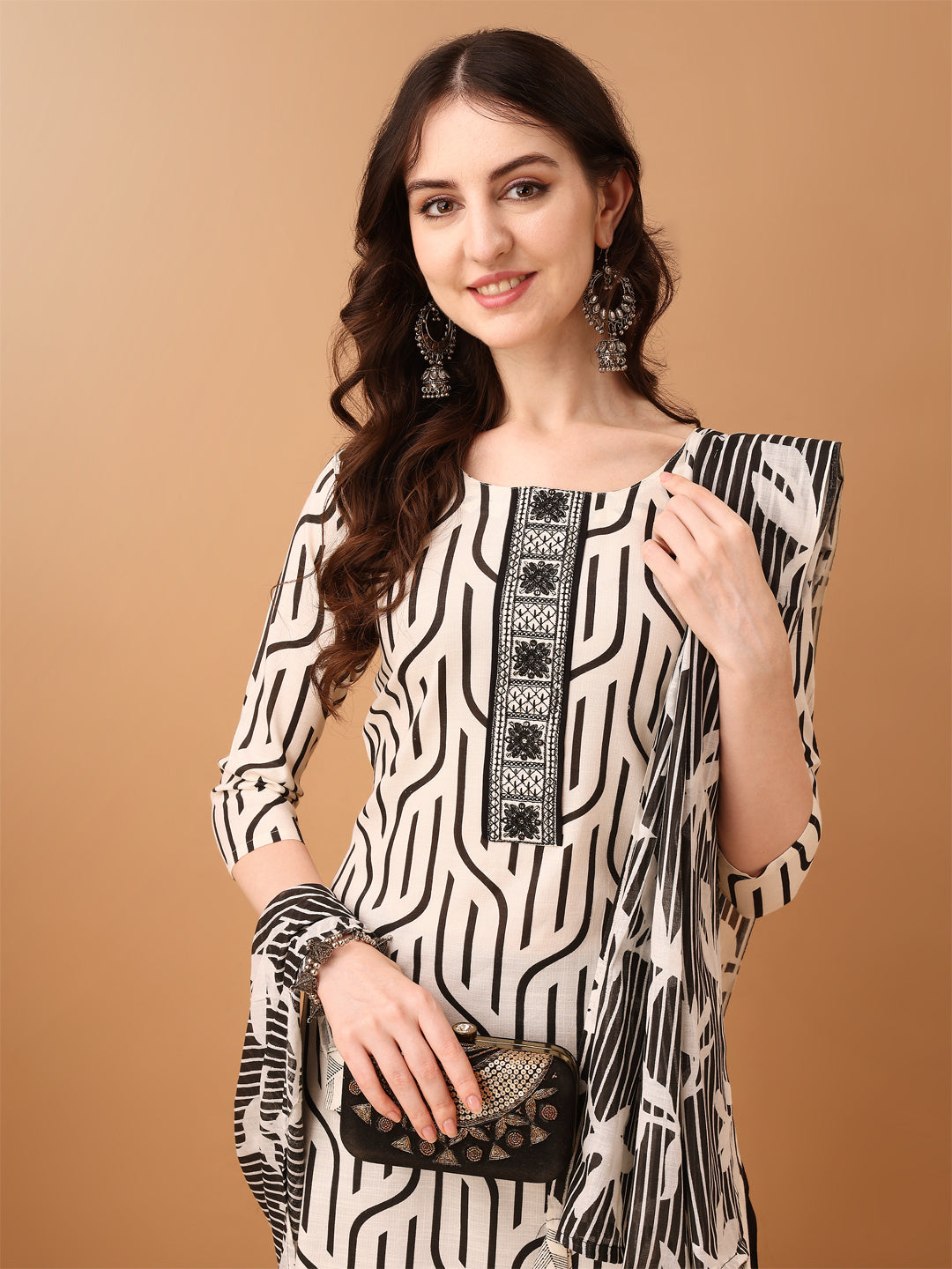 Model wearing a black cotton kurta set with embroidered and printed details, paired with a matching dupatta.