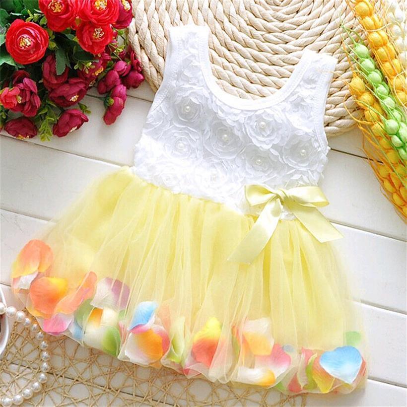Baby girl wearing a sleeveless white floral bodice dress with a layered bright pastel tulle tutu skirt
