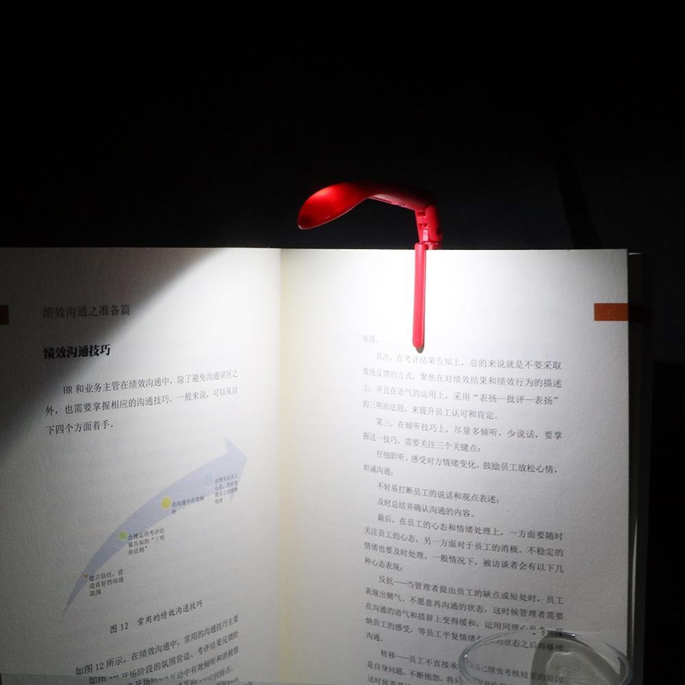 Flexible black clip-on LED book light attached to an open book
