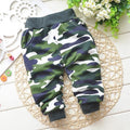 Unisex baby wearing relaxed-fit cotton camouflage pants in olive green and dark-grey