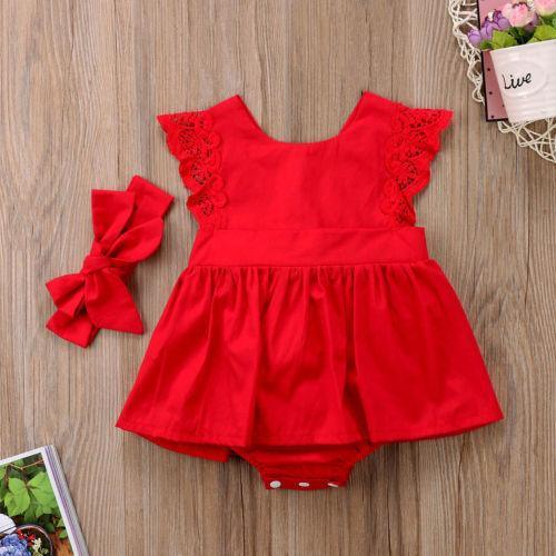 Baby girl wearing a red lace ruffle romper dress with a matching headband.