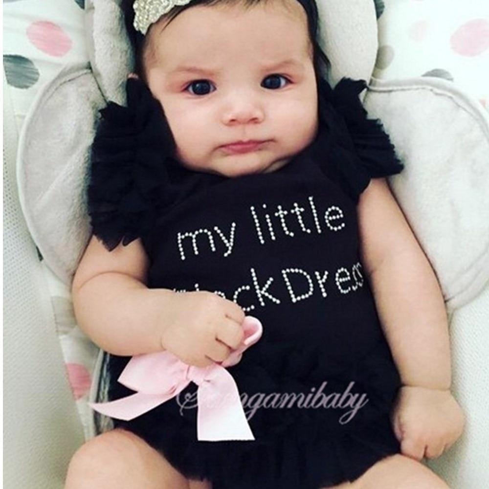 Baby wearing a black cotton blend long-sleeve romper with snap closures for easy diaper changes.