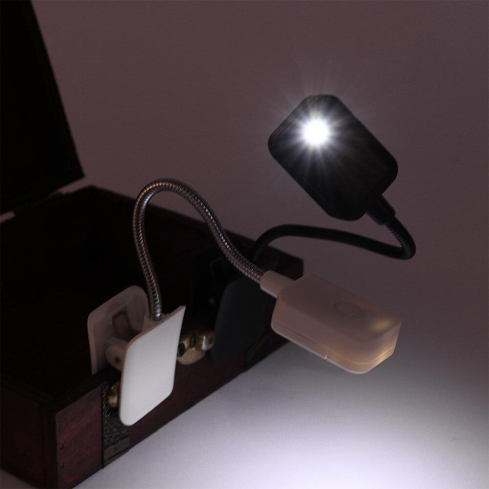 Compact black LED clip-on reading lamp attached to a tablet.