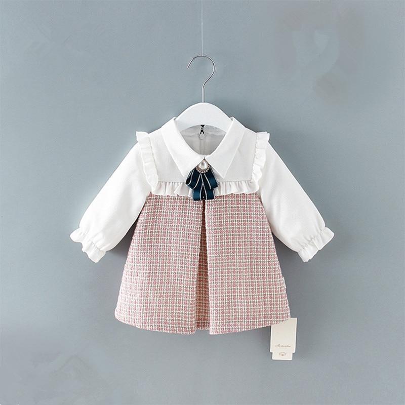 Baby girl wearing a vintage-style plaid A-line dress with lantern sleeves.