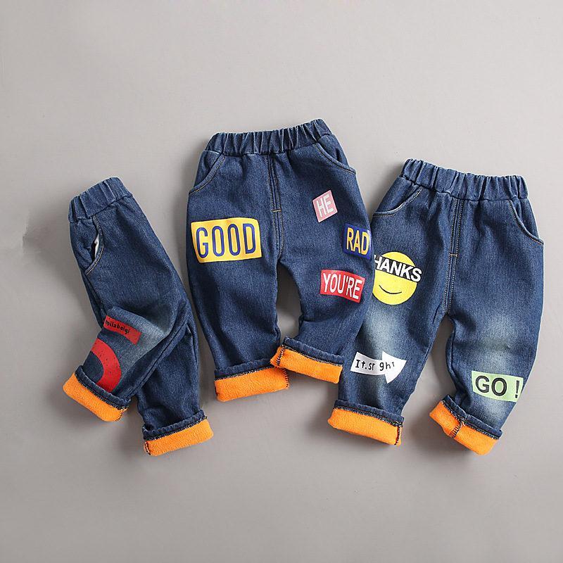 Baby and toddler boy wearing blue and orange cotton denim winter trousers in a casual urban style.