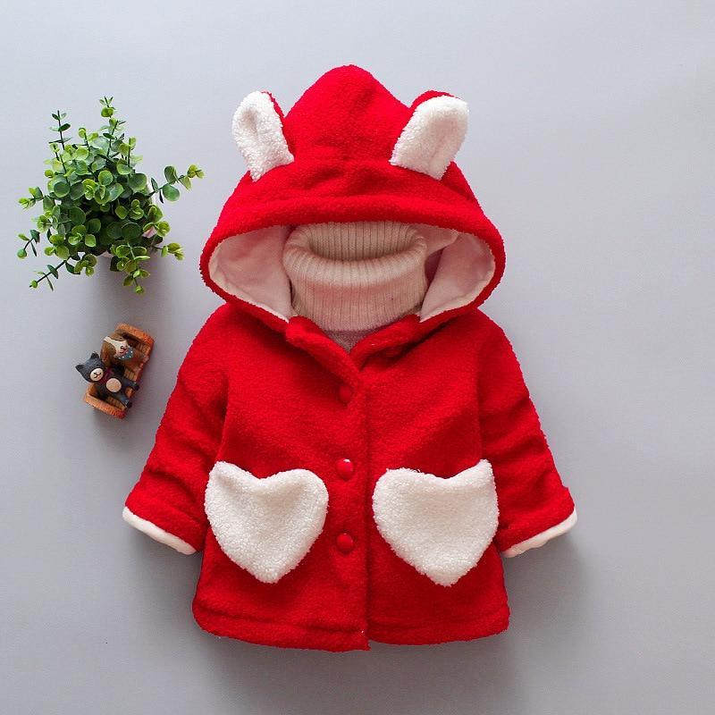 Baby girl wearing a soft velvet winter hoodie jacket with a heart print pattern.