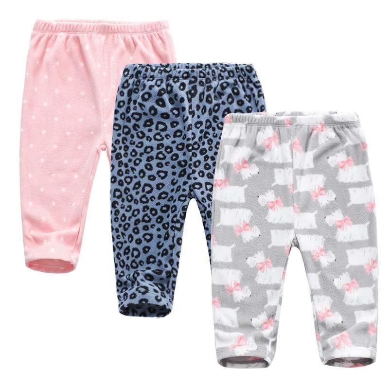 A pair of soft, neutral-colored baby trousers for boys and girls shown folded.