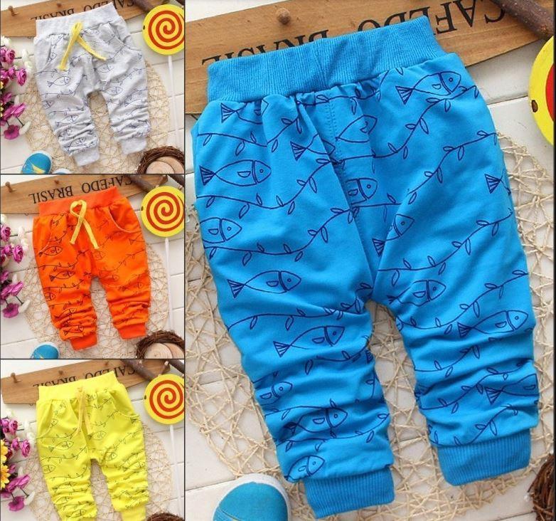 Selection of cotton baby pants in blue, orange, yellow, and grey with animal prints