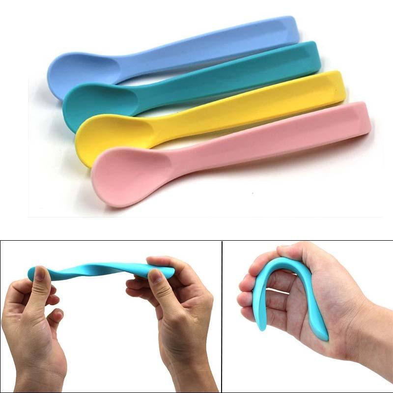 Set of four pastel infant-sized silicone spoons in blue, teal, yellow, and pink