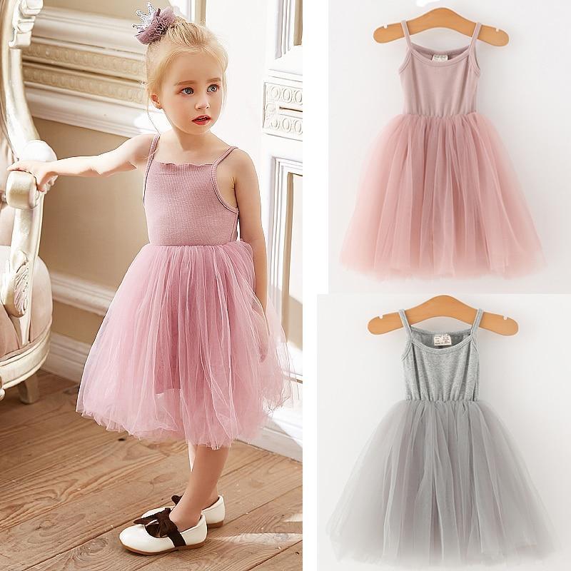 Baby girl wearing a sleeveless pink tulle ballet dress with a fitted cotton bodice for a formal occasion.