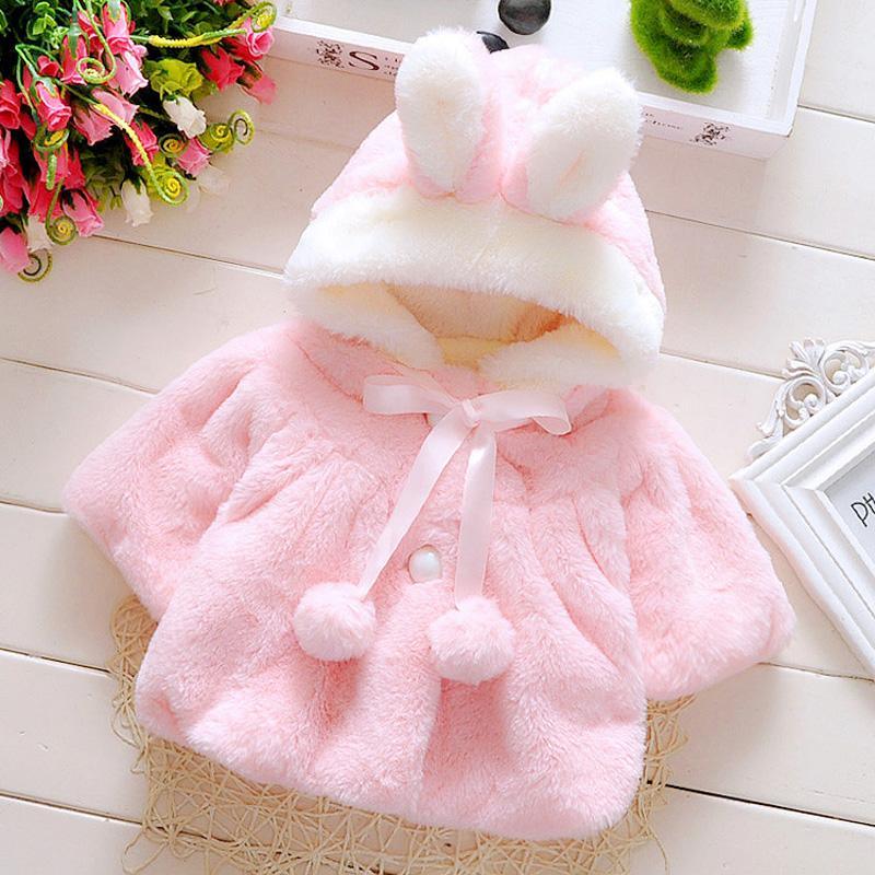 Baby girl wearing a cute, reversible rabbit ear hooded cloak coat in a soft cotton fabric