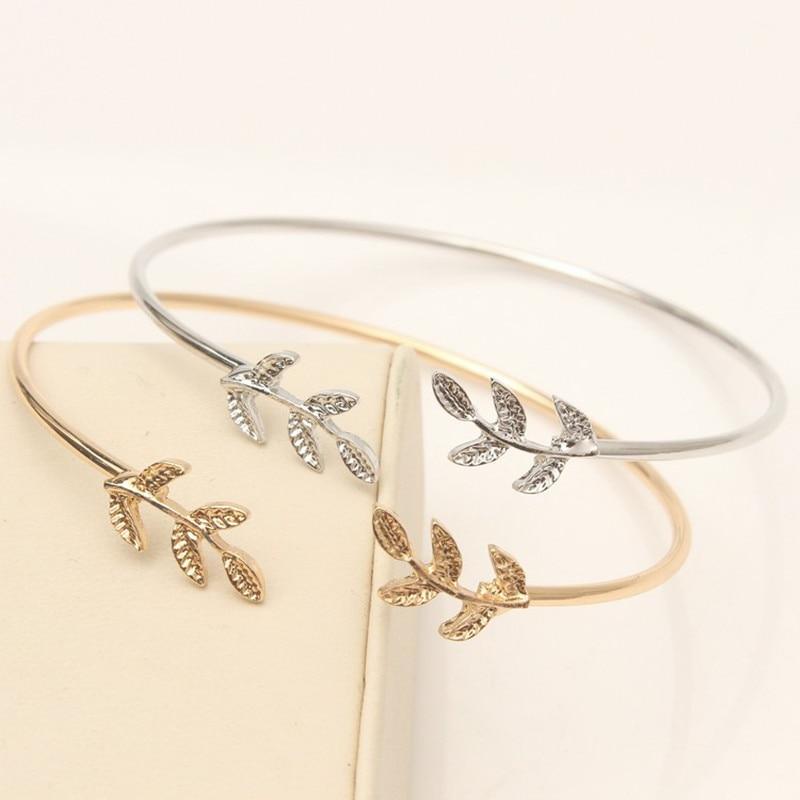 Modern gold and silver plated leaf cuff bracelet worn on a woman's wrist