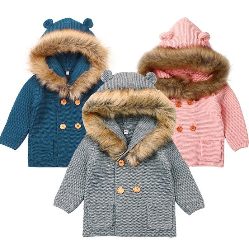 Baby wearing a cozy brown knit hooded cardigan with a bear-themed hood and kangaroo pocket.