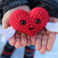 Close up of a handmade red and white crocheted heart using the Happy Heart Amigurumi Pattern