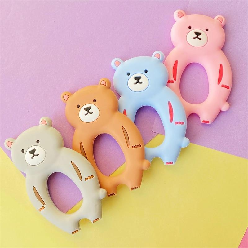 Set of four kawaii bear-shaped silicone baby teethers in pink, blue, brown, and grey