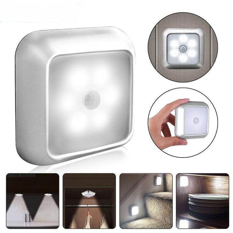 A pair of minimalist white motion sensor LED lamps mounted on a wall in a modern home interior
