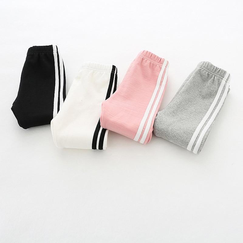 Toddler girl wearing sporty two-bar striped stretch pants for autumn