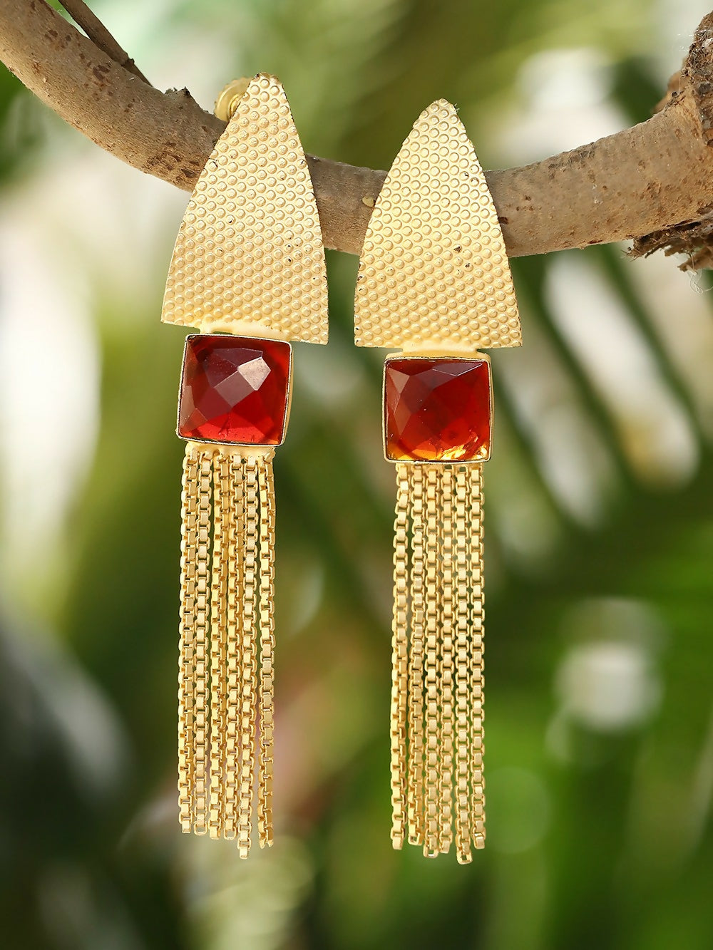 Long matte gold dangle earrings with red stone accent