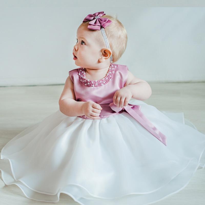 Elegant handmade satin and lace baby girl dress for first birthday in pink and white.