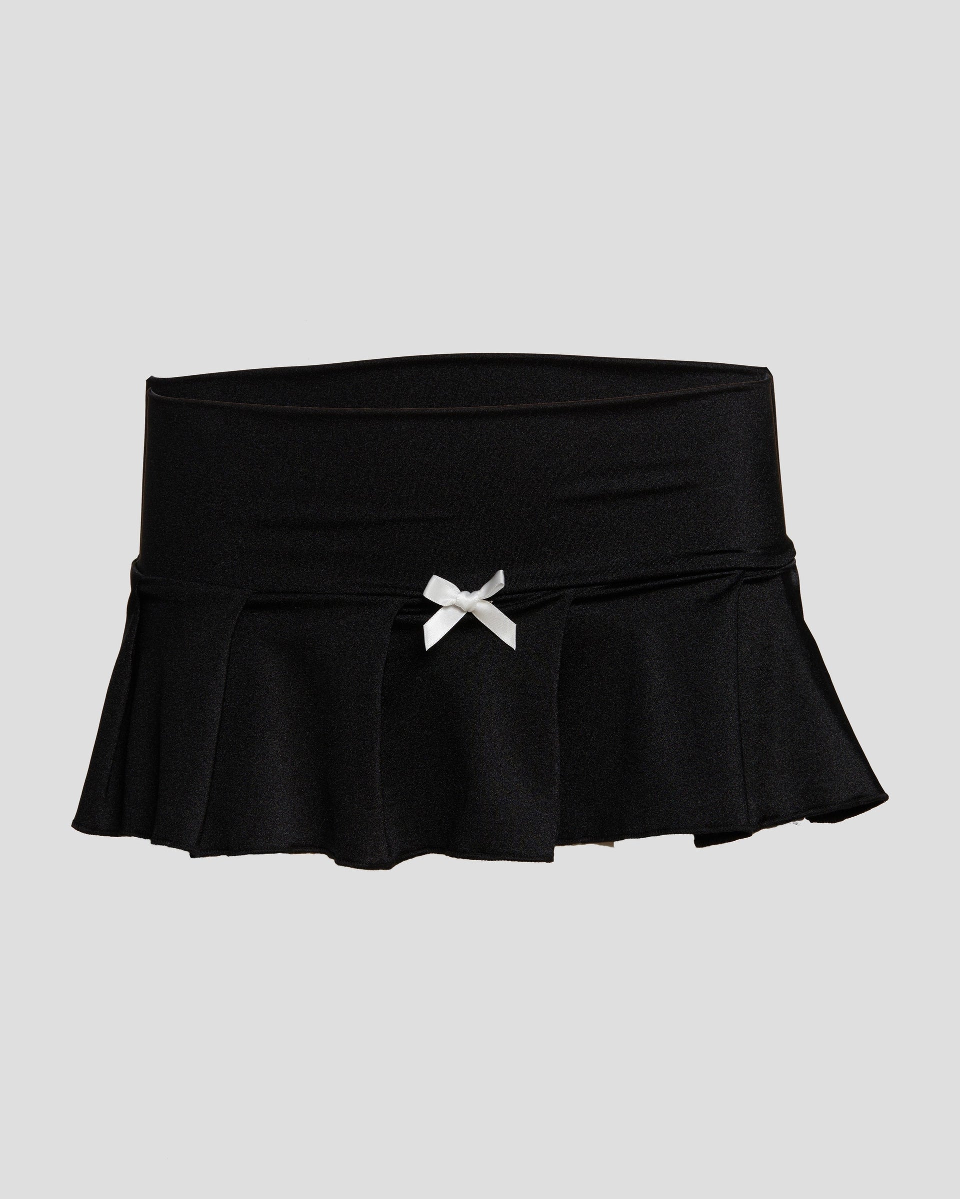 Black and white Kitty Girl micro mini skirt with pleated design, satin bow, and back rhinestone details.