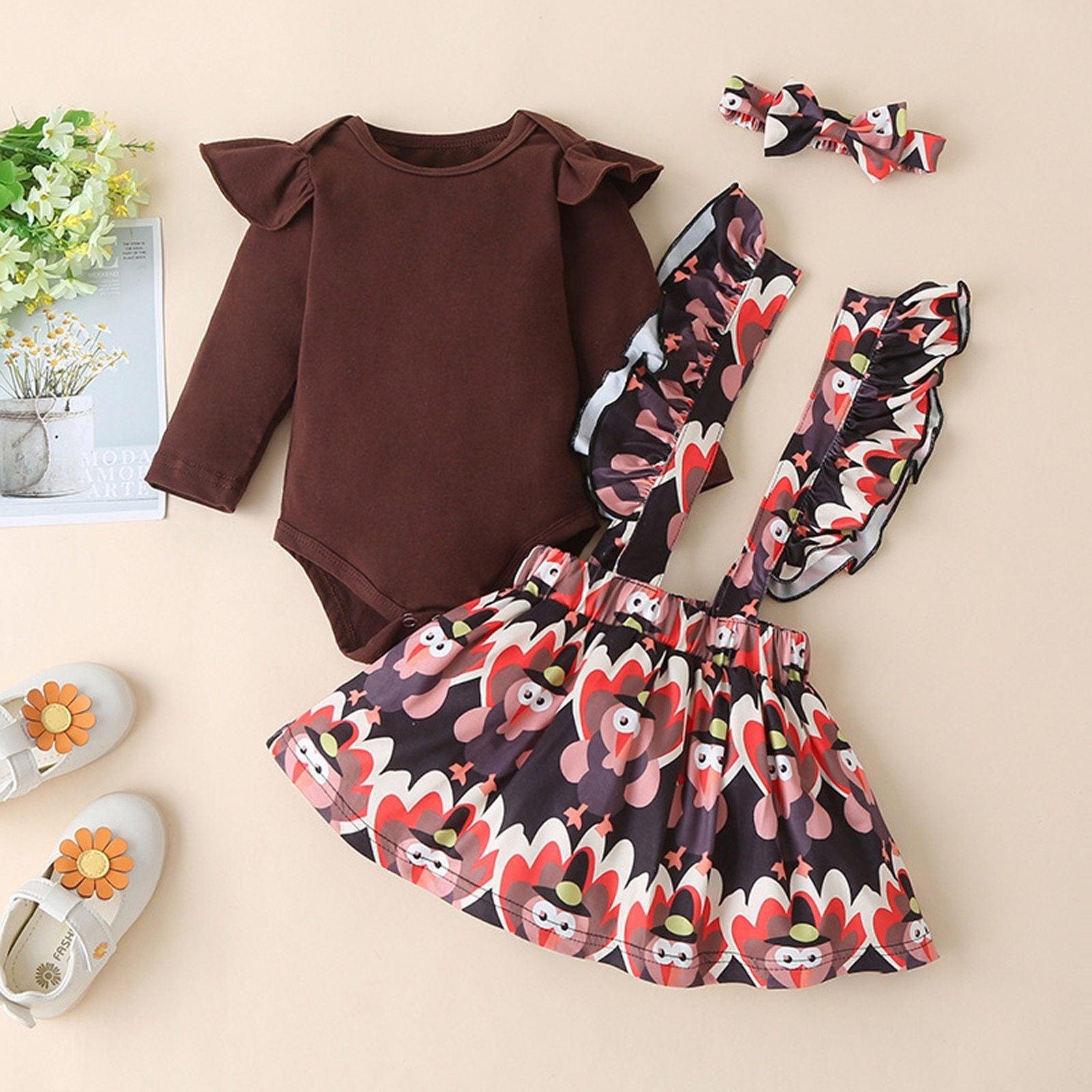 Newborn baby wearing a floral ruffled romper with a button-detail suspender skirt