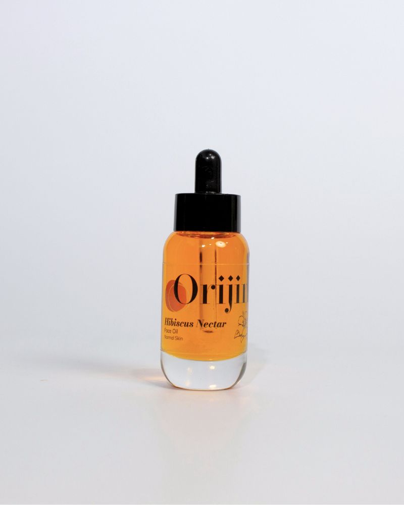 Orijin Hibiscus Nectar face oil in a glass dropper bottle with orange serum against a white background.