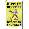 A funny garden flag featuring a rugged, gun-toting frog with the text Hippity Hoppety Get Off My Property on a yellow background.