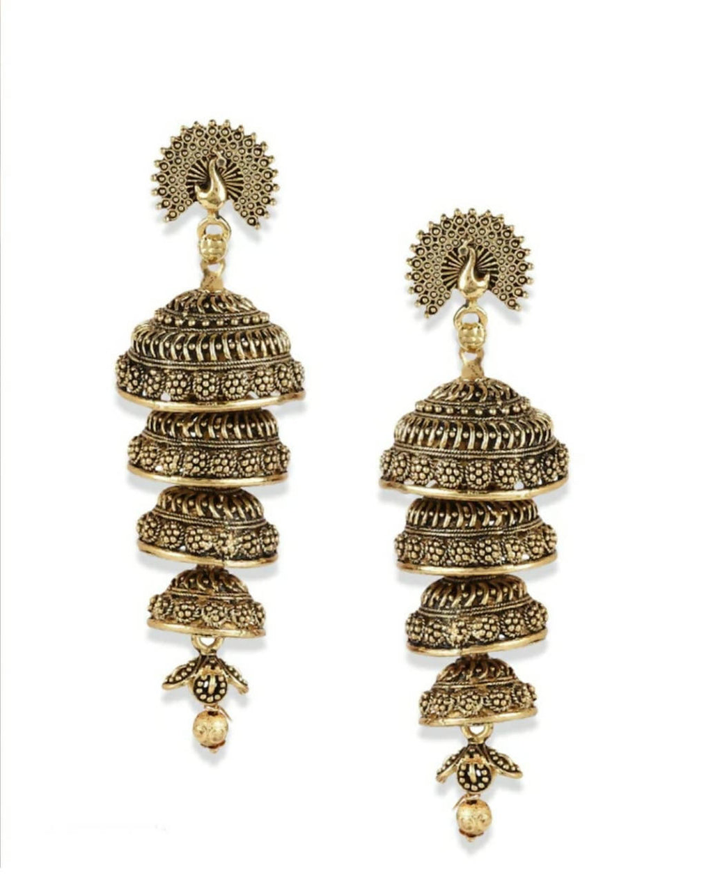 Close-up of bohemian-style peacock design golden earrings with an antique metallic finish